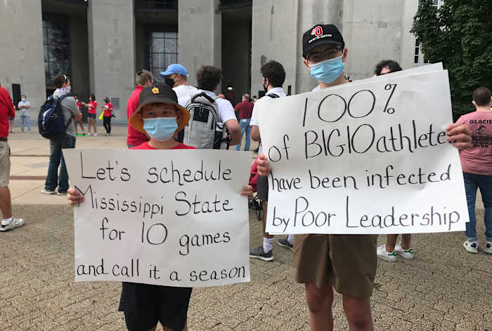 Fans hold signs at Big Ten protest